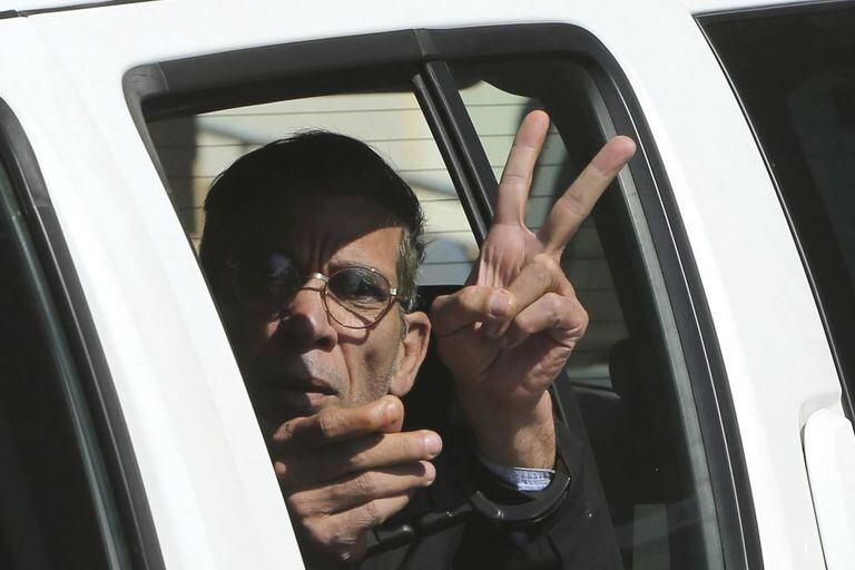 O sequestrador cumprimenta o público, escoltado pela polícia.