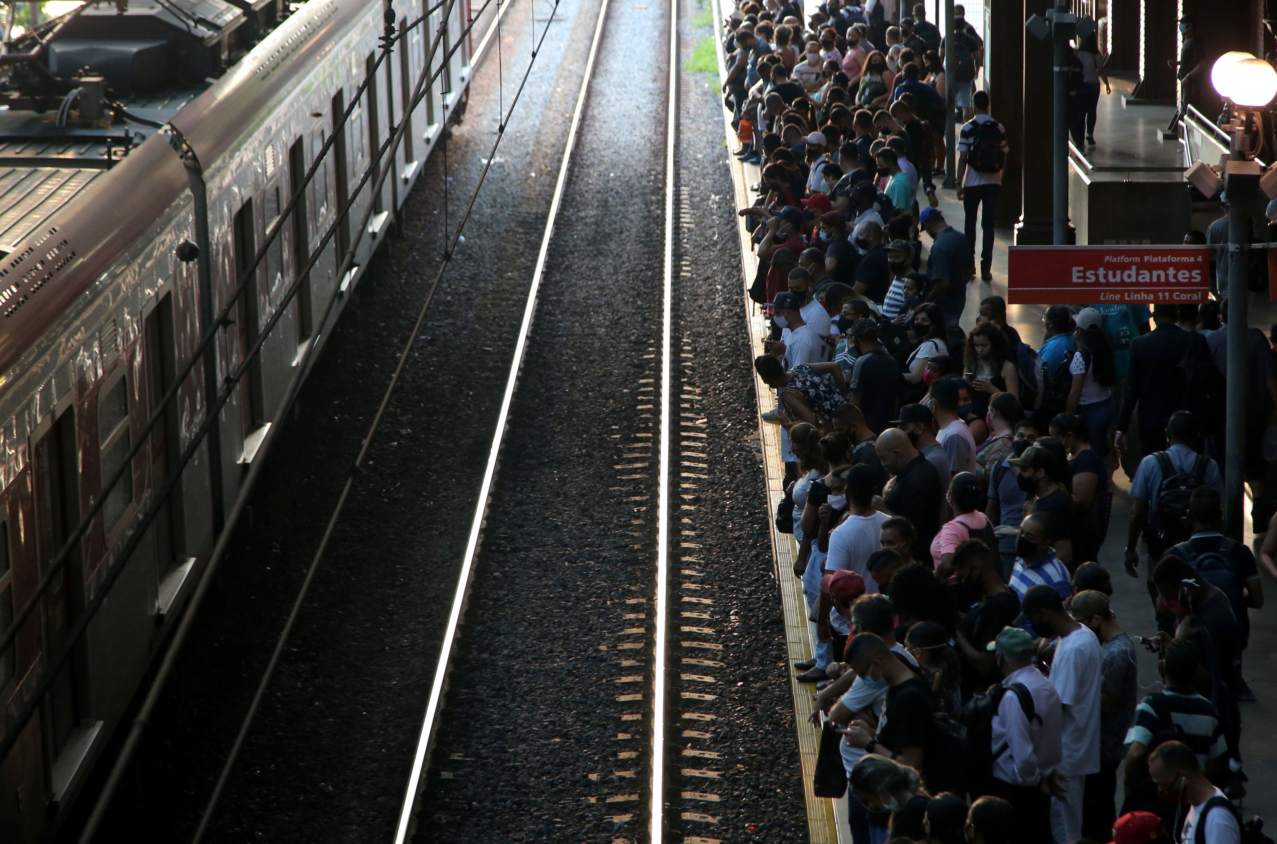 Na Estação da Luz, no centro de São Paulo, trabalhadores fazem fila para entrar nos trens lotados, apesar de o Estado viver a fase emergencial. 