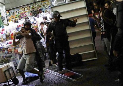 Policial detém manifestante em ato desta sexta.