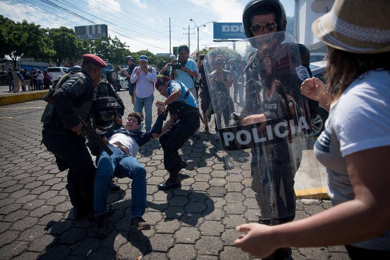 Policiais prendem manifestante na Nicarágua.