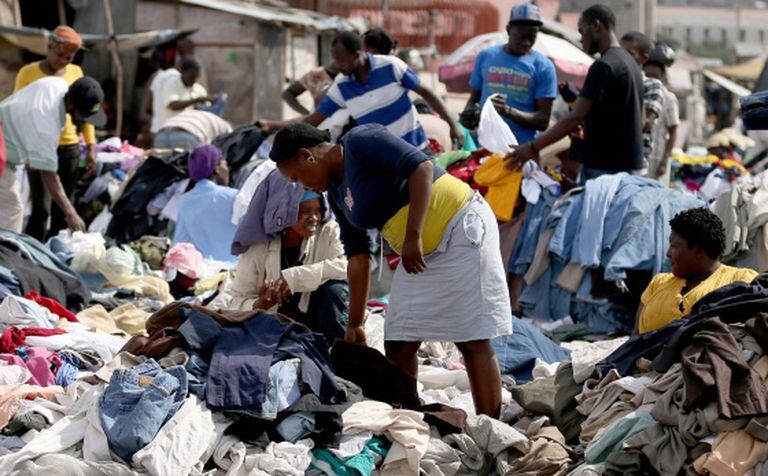 Haitianos compram roupa em um mercado de rua.