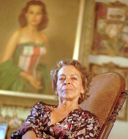 Natalia Revuelta, em sua casa de Havana com seu retrato ao fundo.
