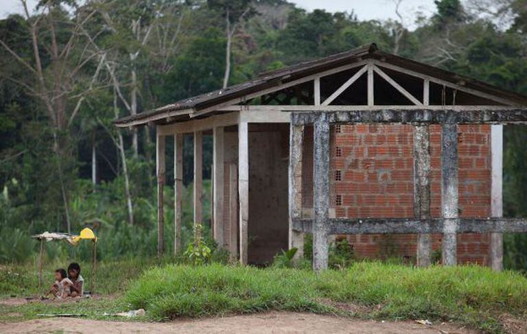 Crianças brincam ao lado de obra abandonada na aldeia Canamary.