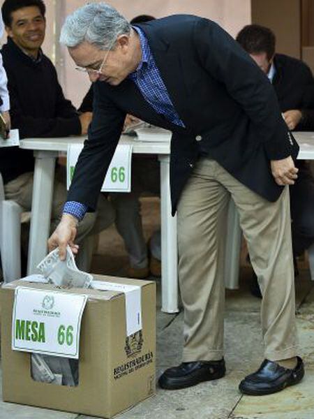 O ex-presidente Álvaro Uribe deposita seu voto na urna.