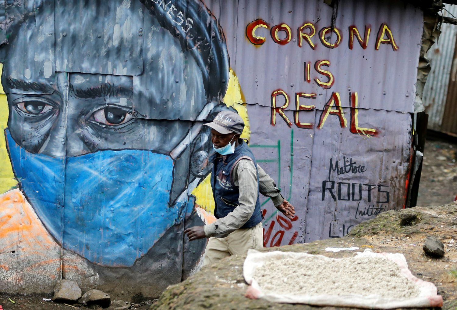 Um homem passa em frente a um mural que adverte sobre o coronavírus no bairro de Mathare, em Nairóbi, capital do Quênia.