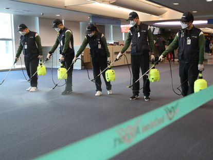 Operários desinfetam a zona alfandegária do aeroporto internacional de Incheon (Coreia do Sul).