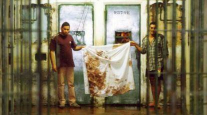 Detentos mostram pano sujo de sangue no Carandiru, em outubro de 1992.
