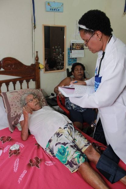 Marlen Cruz Otazo com a paciente Dalila Alves da Silva, em São João de Meriti.