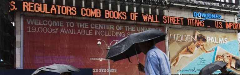 Pedestres na Times Square observam manchetes sobre a crise das subprime, em 2007.