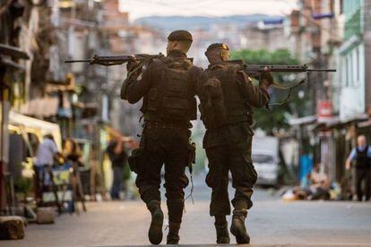 Policiais do BOPE patrulham as ruas das favelas da Maré.