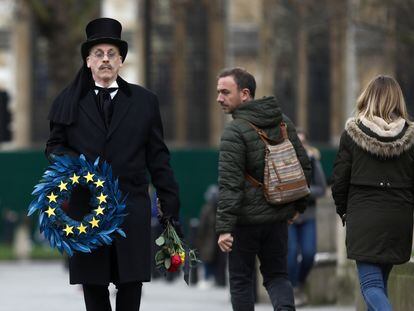 Homem carrega guirlanda em símbolo da União Europeia na praça do Parlamento, em Londres, nesta sexta-feira.