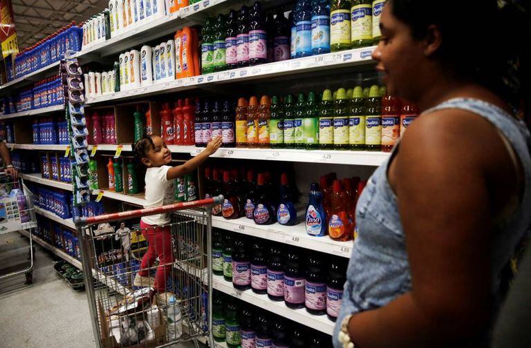 Mulher faz compras com a filha em um mercado de São Paulo.