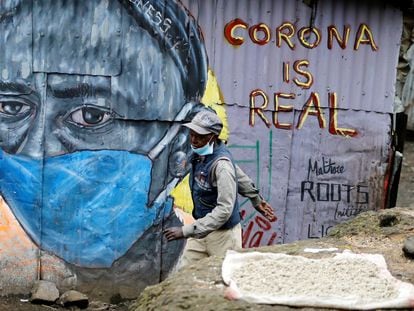 Um homem passa em frente a um mural que adverte sobre o coronavírus no bairro de Mathare, em Nairóbi, capital do Quênia.