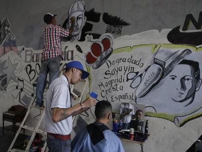 Gilbert Arteaga atende na sexta-feira um cliente em sua barbearia improvisada sob uma ponte em Caracas.