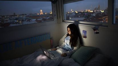 Adolescente assiste a série em seu quarto em Madri, durante a quarentena.
