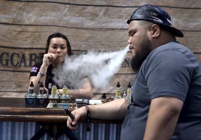 Duas pessoas fumam com cigarros eletrônicos em um encontro em Las Vegas.