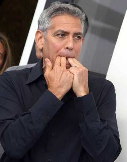 George Clooney assobia no posado ante os fotógrafos em Veneza.