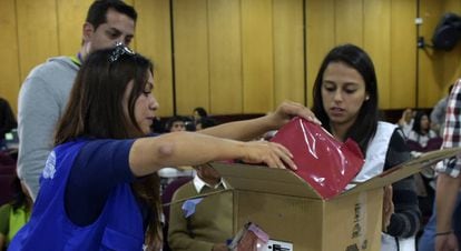 Funcionários da autoridade eleitoral abrem uma caixa com atas da eleição presidencial em Quito.