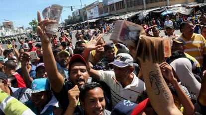 Venezuelanos mostram notas de 100 bolívares