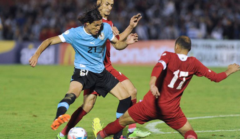 Hatem Aqel y Sharif Nassar disputam a bola com Edinson Cavani.