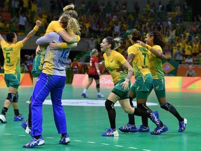 A equipe feminina de handebol comemora a vitória.
