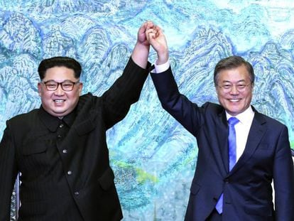 O presidente da Coreia do Norte, Kim Jong-un, e o da Coreia do Sul, Moon Jae-in, levantam os braços durante o encontro de sexta-feira