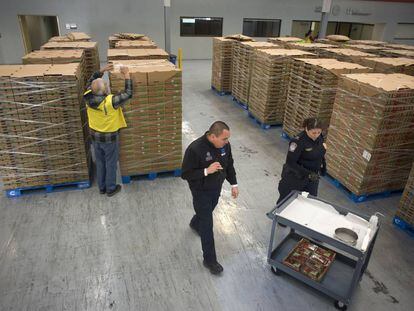 Agentes alfandegários e tributários dos EUA examinam carregamento de morangos em Tijuana (México).