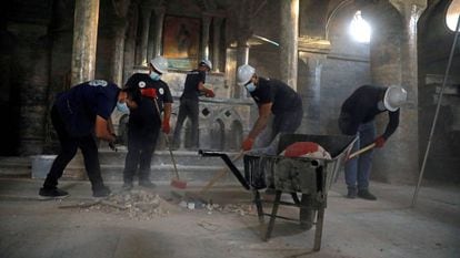 Grupo de voluntários trabalha para limpar a igreja de São Tomás em Mosul (Iraque), profanada pelo Estado Islâmico.