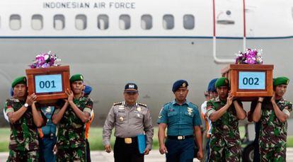 Militares transportam corpos de v&iacute;timas do voo QZ8501. 