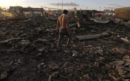 Homem caminha entre os escombros, após a tragédia.