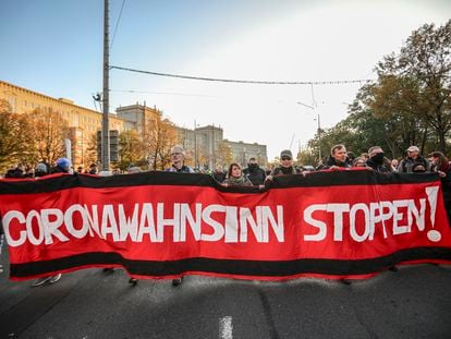 Protesto do movimento Querdenken, que se opõe às medidas de contenção do coronavírus, em 7 de novembro, na cidade de Leipzig. Na bandeira, lê-se "Parem com a loucura do coronavírus".