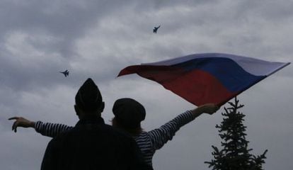 Uma mulher hasteia uma bandeira russa em Sebastopol.