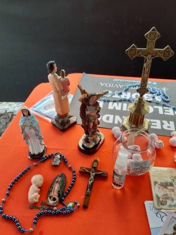 Também há uma mesa com imagens religiosas e crucifixos.