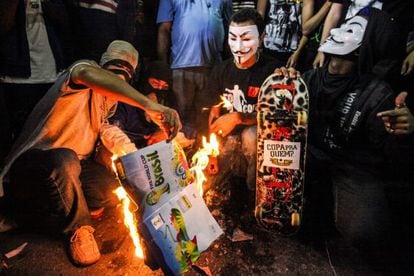 Manifestantes queimam álbum de figurinhas da Copa, nesta quinta, no Rio.