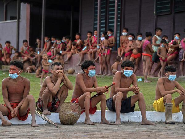 TOPSHOT - EDITORS NOTE: Graphic content / Members of the Yanomami ethnic group wear face masks at a Special Border Platoon, where tests for COVID-19 are being carried out, in the indigenous land of Surucucu, in Alto Alegre, Roraima state, Brazil, on July 1, 2020, amid the new coronavirus pandemic. (Photo by NELSON ALMEIDA / AFP)