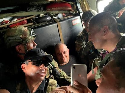 Otoniel, no centro, sorri para uma foto com militares colombianos dentro de um helicóptero após ser capturado.
