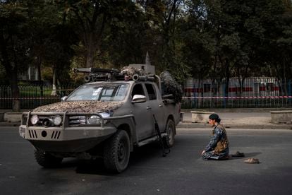 Um combatente talibã reza diante de um veículo militar, na sexta-feira em Cabul.
