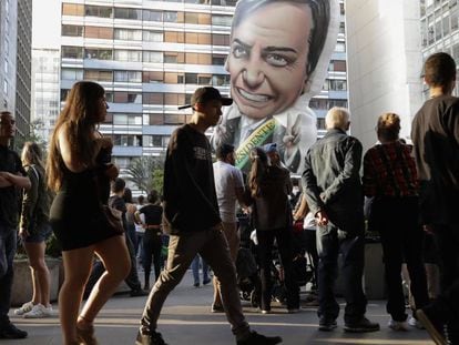 O boneco inflável de Bolsonaro entre pedestres na avenida Paulista no domingo.