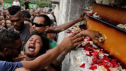 Luciana Nogueira, esposa de Evaldo Rosa dos Santos, no enterro do marido. Amigos do músico protestaram com bandeiras do Brasil manchadas de vermelho