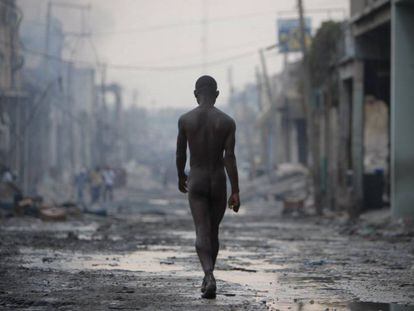 Um homem nu caminha pelas ruas destruídas de Porto Príncipe após o grande terremoto de 12 de janeiro de 2010.