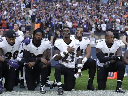 Jogadores dos Ravens se ajoelham durante a execução do hino neste domingo.