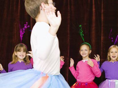Meninos e meninas com saias de balé em um festival escolar.