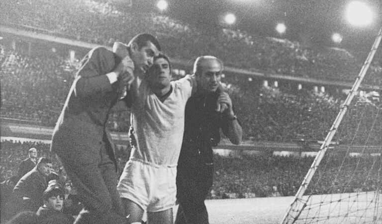 Combin, do Milan, deixa o campo com o rosto ensanguentado.