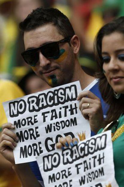 Torcedores do Brasil mostram cartazes contra o racismo.