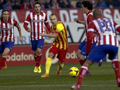 Iniesta conduz a bola entre jogadores do Atlético.
