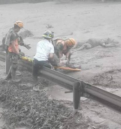 Trabalhos de resgate baixo a chuva de cinza em Guatemala, neste domingo.