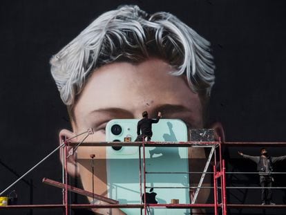 Trabalhadores constroem mural de anúncio de smartphone em Berlim, em outubro de 2020.