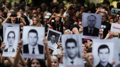 Manifestantes mostram placas com fotos de vítimas da ditadura.