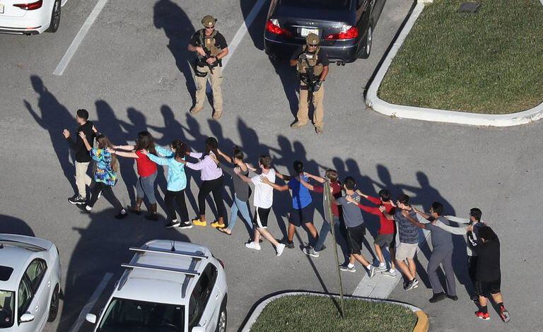 Alunos da escola de Parkland são escoltados por um soldado em fevereiro de 2018.