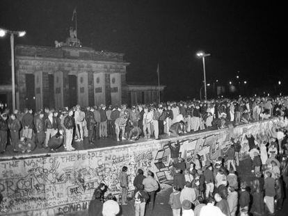 Cidadãos dos dois lados de Berlim celebram sobre o Muro a abertura da fronteira em 9 de novembro de 1989.